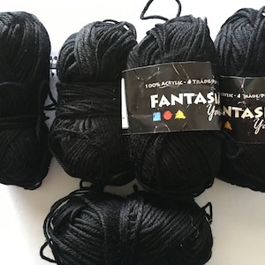 May include: Five balls of black yarn, each with a label that reads "Fantasia Yarn 100% Acrylic - 4 Trade/Ply 50g."