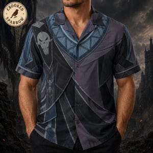 May include: A short-sleeved button-down shirt in shades of black, gray, and dark blue. The shirt features a graphic print of a skull emblem on the chest, geometric patterns around the collar, and the text Crooked Sparrow in a circular logo.