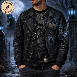 May include: A black long-sleeve sweatshirt featuring a printed design of a layered gothic outfit with a ruffled cravat, a pumpkin emblem, a pocket watch, and a horse silhouette. The graphic includes a dark coat, belts, and buckles.