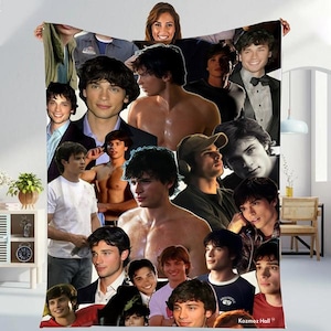 May include: A large, rectangular blanket featuring a collage of images of a person. The images are in various poses and outfits, with a mix of color and black-and-white photos. The blanket is held up by a person.