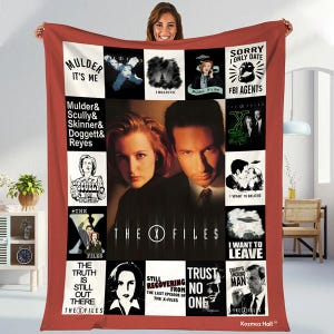 May include: A red throw blanket featuring a collage of images and text from the television show "The X-Files." The blanket includes images of the main characters, phrases like "Mulder It's Me," and the show's logo.