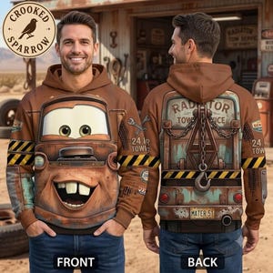 May include: A brown hooded sweatshirt featuring a graphic of a rusty tow truck character with large eyes and a wide smile on the front, and a detailed illustration of the truck's rear with a towing crane and the text Radiator Tow Service.