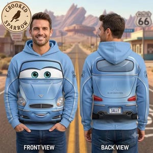 May include: A light blue hooded sweatshirt featuring a car front graphic with large eyes on the chest and a car rear graphic with the text SALLY on the back. The design includes Route 66 symbols on the sleeves and a hood.