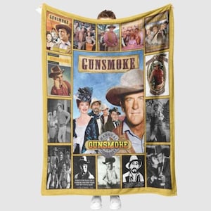 May include: A yellow Gunsmoke-themed blanket featuring a collage of images from the classic Western television series. The blanket showcases various scenes and portraits of characters, with the show's logo prominently displayed in the center. The design includes both color and black-and-white images.