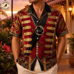 May include: A short-sleeved button-down shirt in deep red with a gold floral pattern. The front features a black diagonal sash, a circular gold buckle, and horizontal gold-toned military-style bars with round buttons. A logo with a bird and the text Crooked Sparrow is visible in the top left corner.