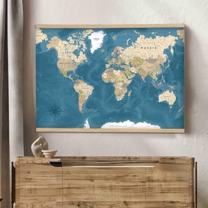 Peut inclure: Une carte du monde rectangulaire encadrée de bois clair, présentant des continents de couleur beige sur un fond d'océan bleu profond. La carte affiche les noms des continents, des pays et des océans avec une typographie lisible.