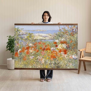 Puede incluir: Gran impresión enmarcada de un vibrante paisaje floral con flores rojas, naranjas y blancas. La obra de arte representa una escena costera con un mar y un cielo azules. El marco es de madera oscura.