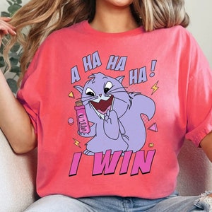 Puede incluir: Una camiseta rosa con un gato morado de dibujos animados que sostiene una botella y se ríe. El texto de la camiseta dice "A HA HA HA! I WIN."