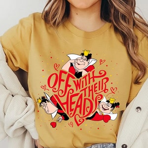 May include: A mustard yellow t-shirt with a red heart graphic featuring the text "Off with their heads" and two cartoon images of the Queen of Hearts from Alice in Wonderland.
