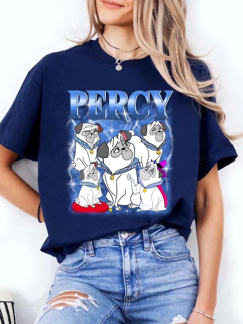 Pode incluir: Camiseta azul marinho com um desenho de v&aacute;rios c&atilde;es pug de desenho animado e o nome "PERCY". Os pugs s&atilde;o brancos com detalhes em preto e usam acess&oacute;rios. O texto "PERCY" est&aacute; em uma fonte azul com raios.
