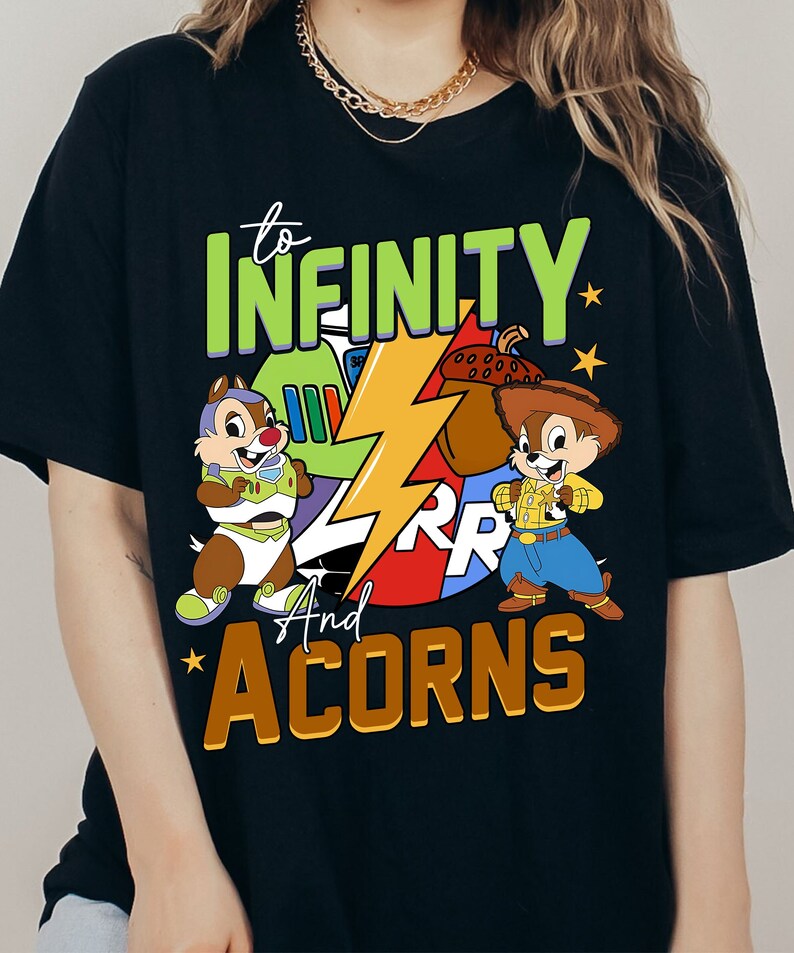 May include: Black t-shirt featuring a graphic of Chip and Dale dressed as Buzz Lightyear and Woody from Toy Story. The text "to INFINITY and ACORNS" is printed on the shirt.