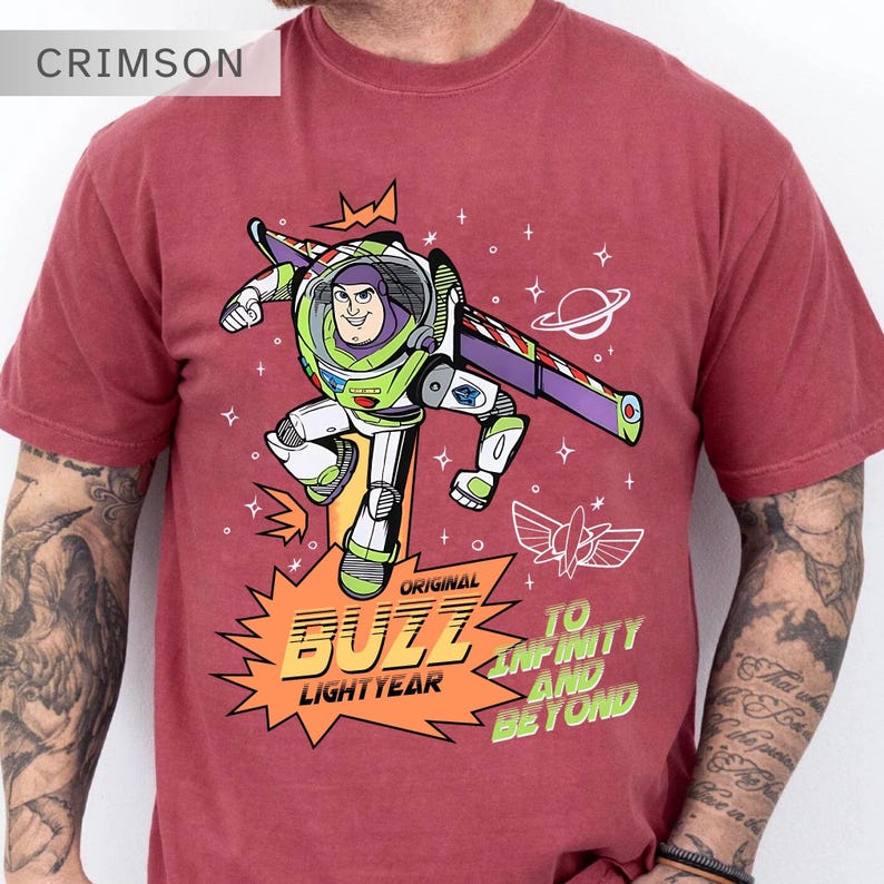 K&ouml;nnte beinhalten: Karmesinrotes T-Shirt mit einem Buzz Lightyear-Motiv. Das Design zeigt Buzz in einer dynamischen Pose, mit den Worten "Original Buzz Lightyear" und "To Infinity and Beyond". Das T-Shirt hat kurze &Auml;rmel.