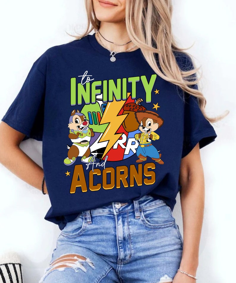 May include: A navy blue t-shirt featuring a graphic of Chip and Dale dressed as Buzz Lightyear and Woody from Toy Story. The text "to infinity and acorns" is printed on the shirt.