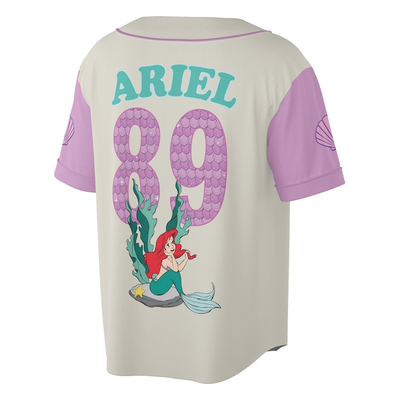 May include: Cream-colored baseball jersey with purple sleeves and accents. The back features the name "ARIEL" in teal, the number "89" in a scale-like pattern, and a graphic of Ariel the mermaid. A seashell design is on the sleeve.