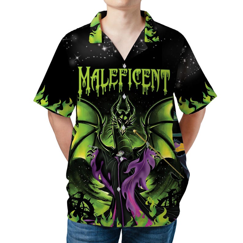 Op de afbeelding: Zwart overhemd met een afbeelding van Maleficent met groene vleugels en een draak. Het shirt heeft het woord "Maleficent" in groene letters. De achtergrond is een sterrenhemel, met groene vlammen op de mouwen.
