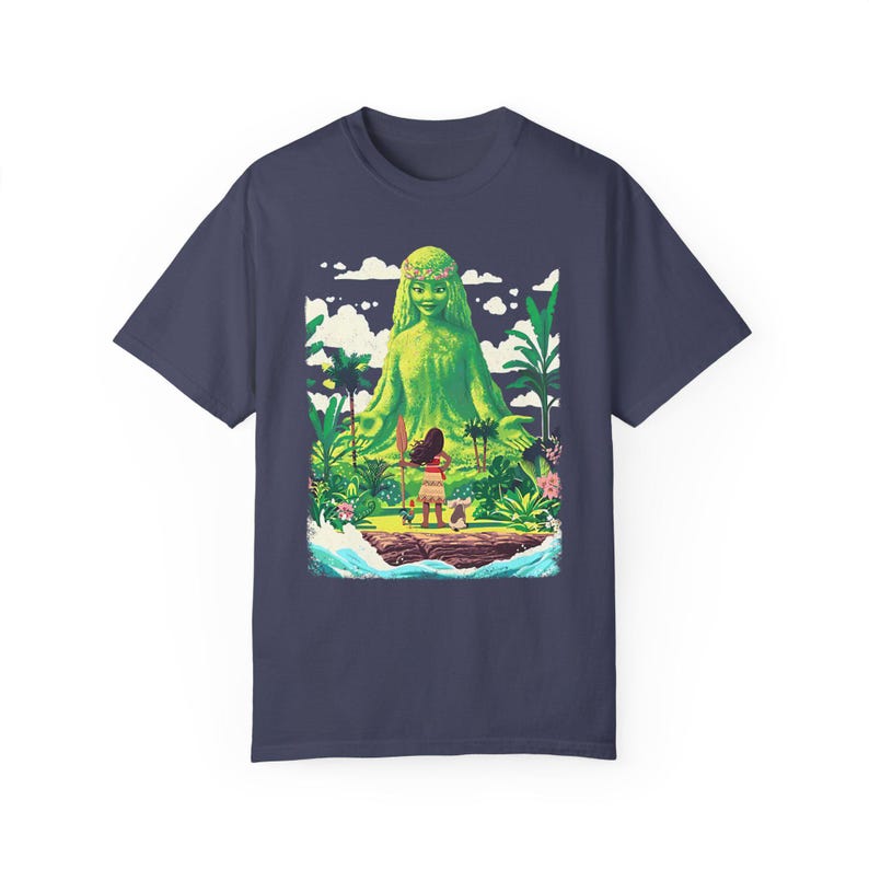 Puede incluir: Una camiseta azul marino con un estampado gr&aacute;fico de una criatura m&iacute;tica femenina verde con una corona de flores. La criatura est&aacute; de pie en una peque&ntilde;a isla con una persona y un animal peque&ntilde;o frente a ella.