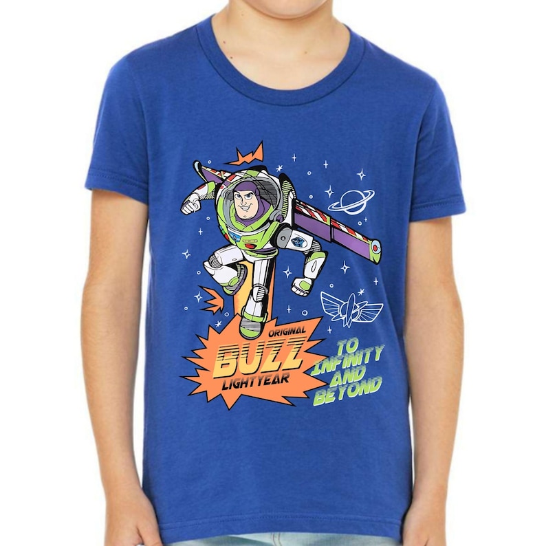 K&ouml;nnte beinhalten: Blaues T-Shirt mit einer Grafik von Buzz Lightyear in einer Flugpose. Das Design enth&auml;lt den Text "Original Buzz Lightyear" und "To Infinity and Beyond". Das T-Shirt hat kurze &Auml;rmel und ein farbenfrohes Design.