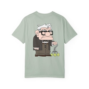 May include: A light green t-shirt featuring a cartoon illustration of an elderly man with glasses, a suit, and a cane with tennis balls. The character is from the animated movie "Up".