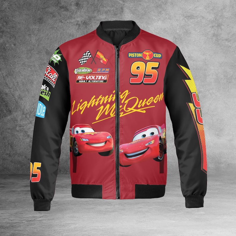 Może przedstawiać: Czerwona i czarna kurtka bomberka z Lightning McQueen z filmu Auta. Kurtka ma numer 95, napisy "Piston Cup", "Lightning McQueen" i inne grafiki. Rękawy są czarne, a korpus czerwony.
