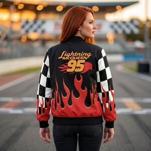 Pu&ograve; includere: Giacca bomber nera con un design ispirato al personaggio Saetta McQueen del film Cars. La giacca presenta un motivo a scacchi sulle maniche, il numero 95 e un design a fiamma in rosso e arancione.