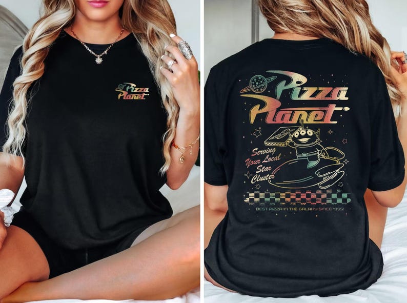 Puede incluir: Camiseta negra con un gr&aacute;fico colorido del logotipo de Pizza Planet y un personaje de la pel&iacute;cula Toy Story. El texto en la camiseta dice "Pizza Planet", "Serving Your Local Star Cluster", y "Best Pizza in the Galaxy Since 1995".