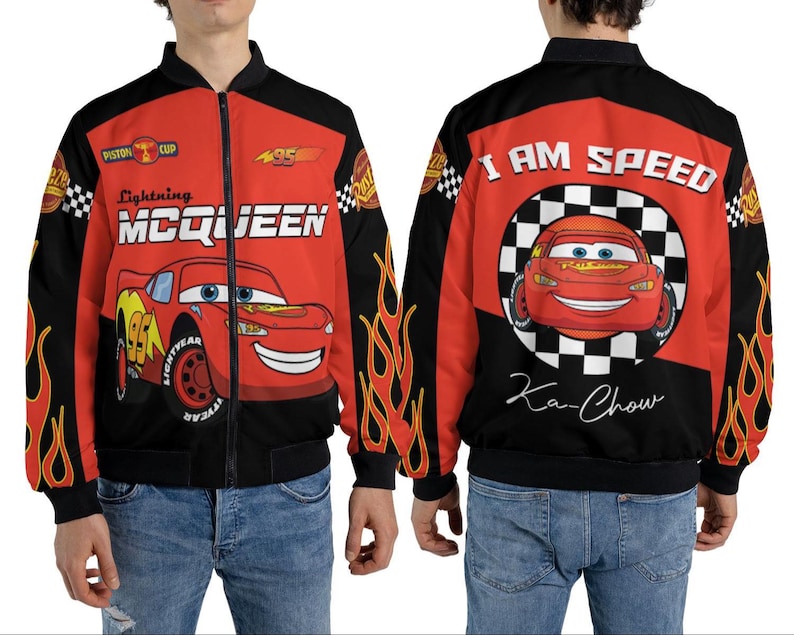 May include: A red and black Lightning McQueen bomber jacket. The front features the character's name and image, while the back displays "I AM SPEED" and "Ka-Chow." Flames adorn the sleeves. The jacket is worn by a person.