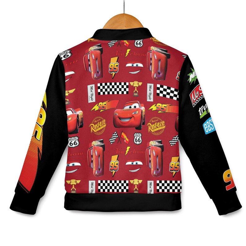 May include: A red and black jacket featuring a pattern of cartoon race cars, lightning bolts, and checkered flags. The jacket has black sleeves and a collar. The design includes the number 95 and the word "Rusteze".