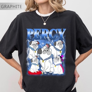 Pode incluir: Camiseta preta com um gr&aacute;fico de pugs brancos com coleiras azuis e o nome "PERCY" em azul. O design &eacute; colocado sobre um fundo azul com raios. A camiseta tem um corte folgado.