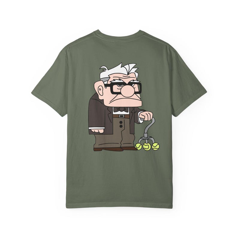 May include: Olive green t-shirt featuring a cartoon illustration of an elderly man with glasses, a suit, and a cane with tennis balls. The character is from the animated movie "Up".