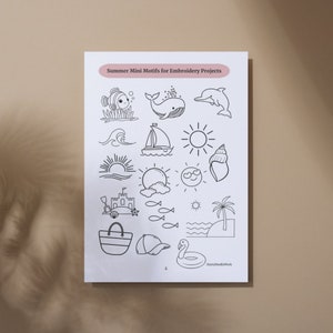May include: A printable sheet of 16 black and white summer-themed embroidery motifs. The motifs include a whale, a sailboat, a seashell, a sun, a beach umbrella, a sandcastle, a fish, a palm tree, a beach bag, a baseball cap, and a flamingo float.