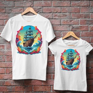 May include: Two white t-shirts with a colorful graphic of a ship sailing on a stormy sea. The graphic is surrounded by a circle of colorful smoke.