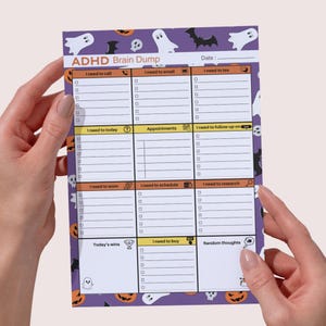 May include: A Halloween-themed ADHD Brain Dump notepad with a purple background and orange accents. The notepad features sections for tasks like calls, emails, and appointments, with ghost and pumpkin illustrations. The text "ADHD Brain Dump" is at the top.