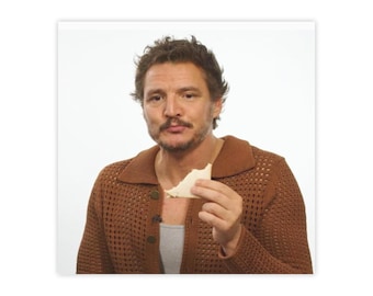 Puede incluir: Un hombre con cabello castaño y un suéter marrón está comiendo un trozo de pan blanco.