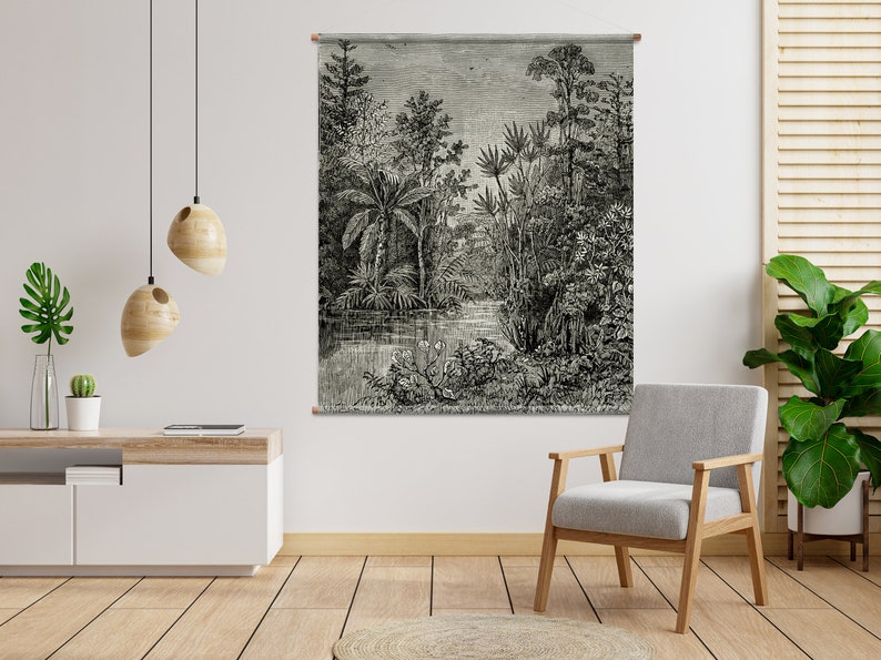 May include: Black and white illustration of a tropical jungle scene with palm trees, ferns, and a river. The illustration is framed and hanging on a white wall.