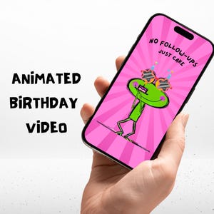 以下が含まれることがあります： スマートフォンには、サングラスをかけたカエルの漫画とケーキが描かれたピンク色の画面が表示されています。画面のテキストは「NO FOLLOW-UPS JUST CAKE」と表示されています。「Animated Birthday Video」という言葉が左側に書かれています。