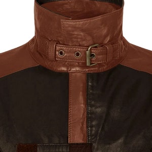 May include: A brown leather jacket with a black leather collar and a brown leather belt with a buckle. The jacket has a brown leather stripe down the front.