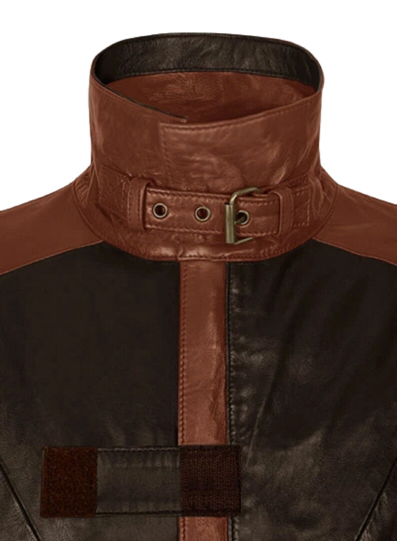 May include: A brown leather jacket with a black leather collar and a brown leather belt with a buckle. The jacket has a brown leather stripe down the front.
