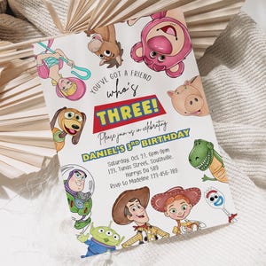 Op de afbeelding: Een kleurrijke verjaardagsuitnodiging met personages uit een populaire animatiefilm. De uitnodiging luidt "You've got a friend who's THREE!" en bevat feestdetails. Het ontwerp staat tegen een neutrale achtergrond.