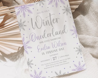 May include: A white invitation card with a winter theme. The card features the text "Winter Onederland" in silver glitter and purple snowflakes. The card also includes the name "Emilia Wilson" and the date of the event.
