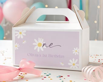 以下が含まれることがあります： 白いギフトボックス、持ち手付き。デイジーの花と「one」と「Olivia's 1st Birthday」の文字がラベンダー色の背景に描かれています。 ピンクのリボンと紙吹雪が前景にあります。 背景には風船があります。