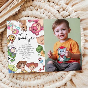 May include: A personalized birthday thank you card featuring a smiling child and a colorful illustration of Toy Story characters. The card includes the text "Thank you" and a handwritten message.
