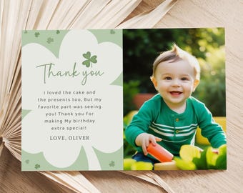 May include: A birthday thank you card with a photo of a smiling baby wearing a green shirt. The card has a light green shamrock design and the text "Thank you" and a personal message.