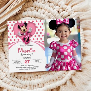 Puede incluir: Una invitación de cumpleaños rosa con el tema de Minnie Mouse. La invitación incluye el texto "Madeline cumple 2 años" y la fecha 27 de enero de 2026. Una niña pequeña con un disfraz de Minnie Mouse también está en la imagen.
