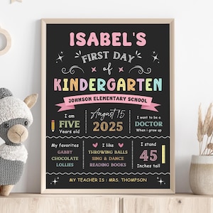 Può includere: Un cartello nero a forma di lavagna con il testo "ISABEL'S FIRST DAY OF KINDERGARTEN" in colori arcobaleno. Il cartello include anche dettagli sull'età di Isabel, la sua altezza, le sue cose preferite e le sue aspirazioni future. Il cartello è decorato con stelle e cuori.