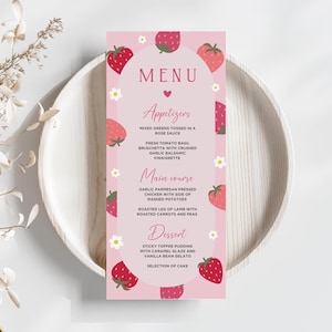 Può includere: Un biglietto del menu rosa a tema fragola, con la parola "MENU" in alto. Il menu elenca antipasti, piatti principali e dessert, con illustrazioni di fragole e accenti floreali. Il biglietto è appoggiato su un piatto di legno bianco.