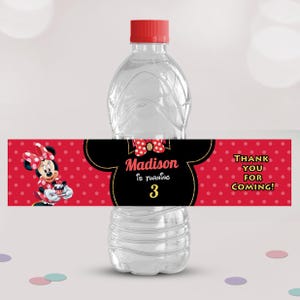 Peut inclure: Une bouteille d'eau transparente avec un bouchon rouge. La bouteille porte une étiquette Minnie Mouse rouge et noire. L'étiquette indique "Madison a 3 ans" et "Merci d'être venus !" en lettres blanches et dorées.