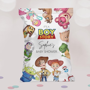 Peut inclure: Un sac de fête blanc avec des personnages de Toy Story. Le sac porte l'inscription "It's a Boy Story" et "Sophie's Baby Shower". Des images de dessins animés de Woody, Buzz Lightyear et d'autres personnages sont affichées.