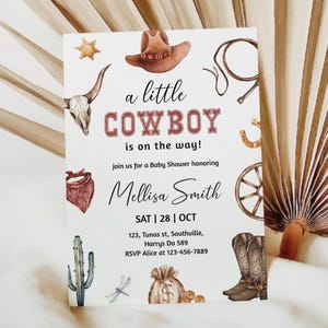 May include: A white baby shower invitation with a watercolor illustration of a cowboy hat, boots, a cactus, a lasso, a horseshoe, a wagon wheel, a skull, a bandana, a dragonfly, and a money bag. The text reads "a little COWBOY is on the way!" and "join us for a Baby Shower honoring Mellisa Smith SAT | 28 | OCT 123, Tunas st, Southuille, Harrys Da 589 RSVP Alice at 123-456-7889"