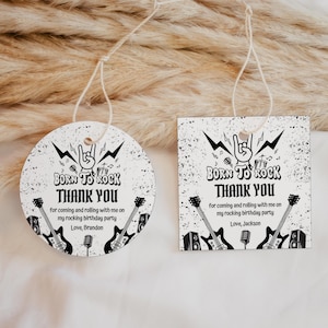 May include: Two white, rock-themed thank you tags. One is round, the other square. Both feature the text "BORN TO ROCK THANK YOU" with guitars, a microphone, and the name "Brandon" or "Jackson".