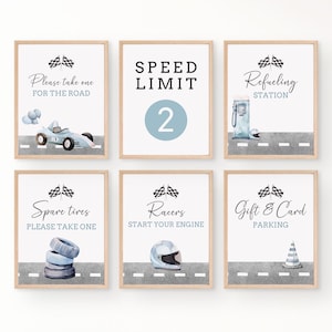 May include: Six printable signs for a race car themed party. The signs are white with black text and blue accents. The signs say "Please take one for the road", "Speed Limit 2", "Refueling Station", "Spare tires please take one", "Racers start your engine", and "Gift & Card Parking".